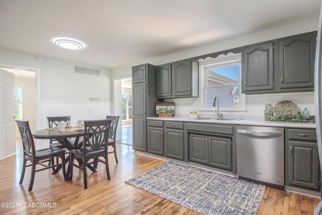12271 County Road 4037, Holts Summit, MO 65043 - kitchen with dishwasher, a sink, plenty of natural light, light countertops, and a wainscoted wall