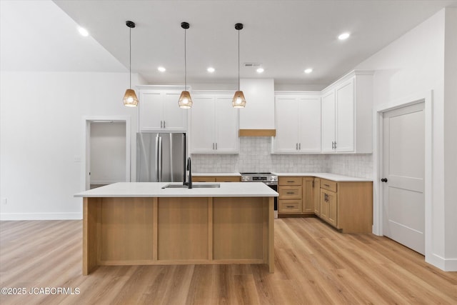 7058 County Road 409, Fulton, MO 65251 - kitchen featuring stainless steel appliances, light wood-style floors, backsplash, a kitchen island with sink, and light countertops
