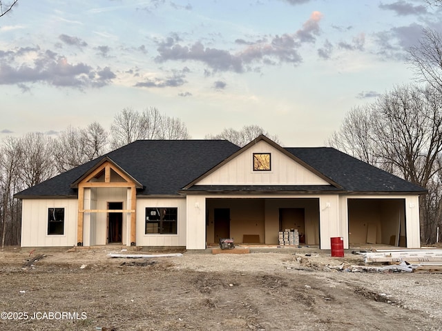 modern farmhouse style home with an attached garage, board and batten siding, and a shingled roof