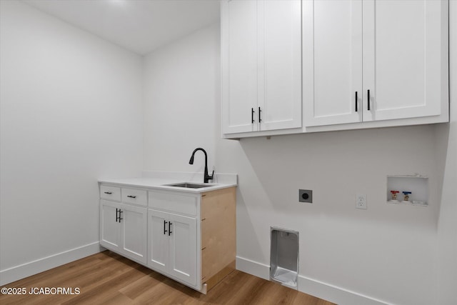 7058 County Road 409, Fulton, MO 65251 - laundry area with electric dryer hookup, light wood finished floors, hookup for a washing machine, and cabinet space