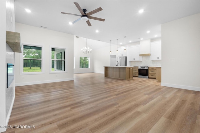 7058 County Road 409, Fulton, MO 65251 - unfurnished living room with a chandelier, a ceiling fan, plenty of natural light, recessed lighting, and light wood-style flooring