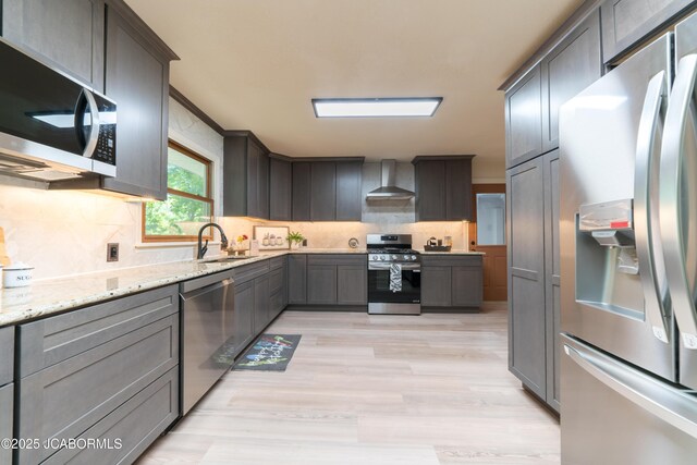 232 Pheasant Ln, Holts Summit, MO 65043 - kitchen with appliances with stainless steel finishes, wall chimney range hood, backsplash, and light stone countertops