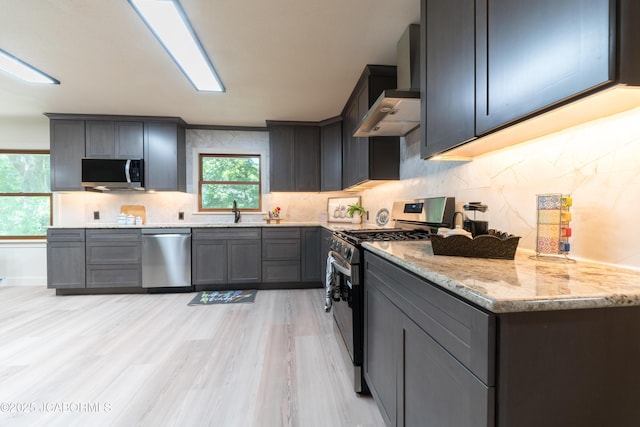232 Pheasant Ln, Holts Summit, MO 65043 - kitchen featuring appliances with stainless steel finishes, custom exhaust hood, light stone counters, light wood-style floors, and tasteful backsplash