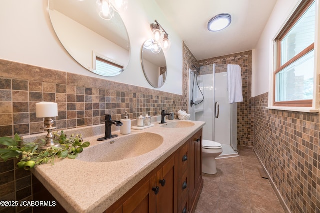 232 Pheasant Ln, Holts Summit, MO 65043 - full bathroom featuring tile walls, double vanity, a shower stall, tile patterned floors, and wainscoting