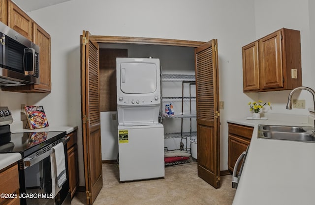 808 Park De Ville Pl, Columbia, MO 65203 - kitchen with appliances with stainless steel finishes, estacked washer and dryer, light carpet, and light countertops
