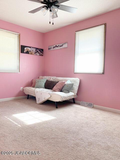 living area featuring ceiling fan and carpet floors