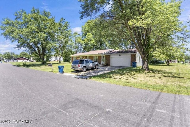 view of front of property with a garage, driveway, a front lawn, and brick siding