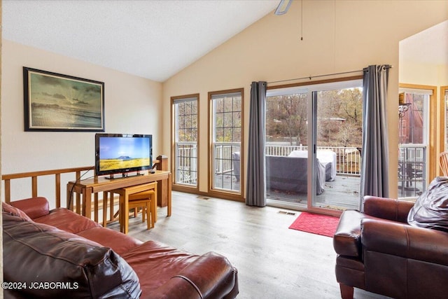 living room featuring visible vents, lofted ceiling, a healthy amount of sunlight, and wood finished floors