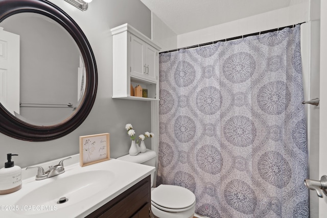 bathroom featuring toilet, a shower with shower curtain, and vanity