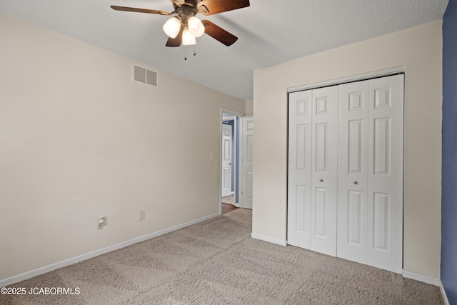 unfurnished bedroom with ceiling fan, visible vents, baseboards, a closet, and carpet flooring