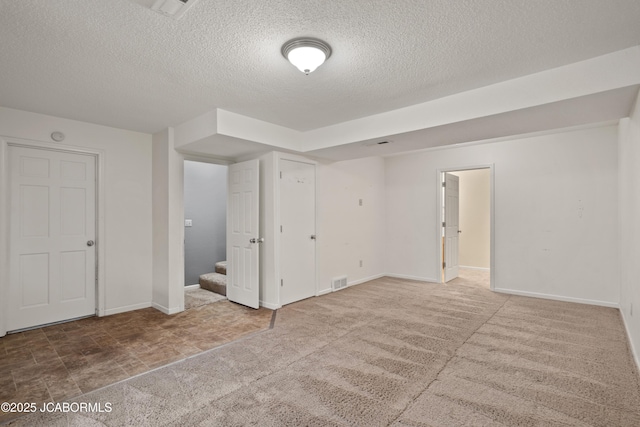 interior space with stairs, a textured ceiling, visible vents, and baseboards