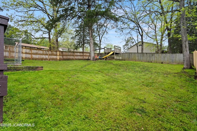 view of yard featuring a fenced backyard and a playground