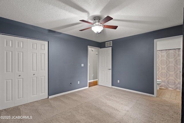 unfurnished bedroom featuring visible vents, baseboards, carpet floors, and a closet