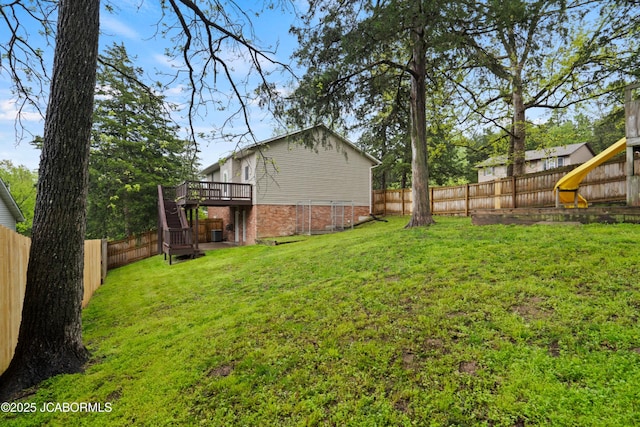 view of yard featuring a fenced backyard, a deck, and stairway