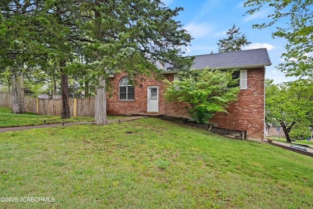 view of front of home featuring fence, a front yard, and brick siding