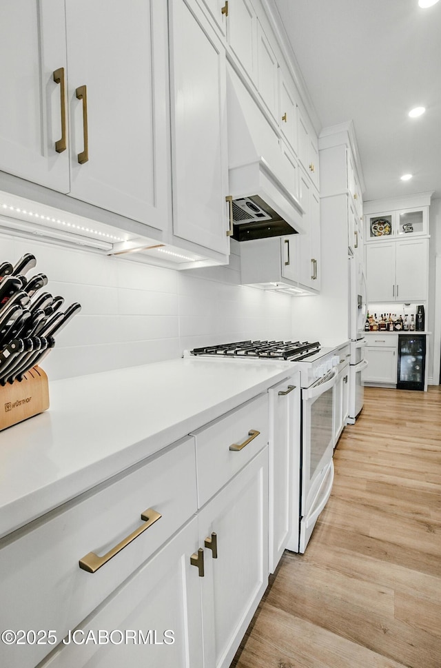 5621 Lightpost Dr, Columbia, MO 65201 - kitchen featuring white appliances, beverage cooler, white cabinets, recessed lighting, and light wood-type flooring
