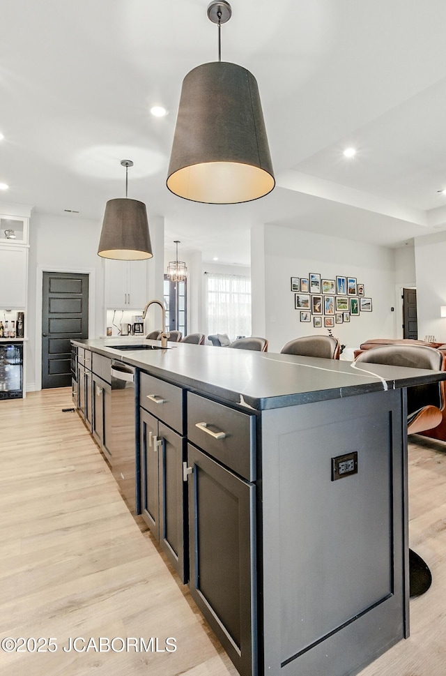 5621 Lightpost Dr, Columbia, MO 65201 - kitchen featuring dishwasher, open floor plan, light wood-type flooring, a kitchen island with sink, and recessed lighting