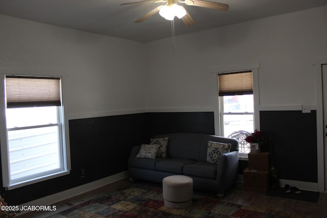 living room with baseboards, wood finished floors, and ceiling fan