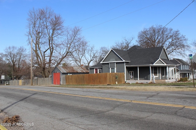 view of front of property featuring fence and covered porch