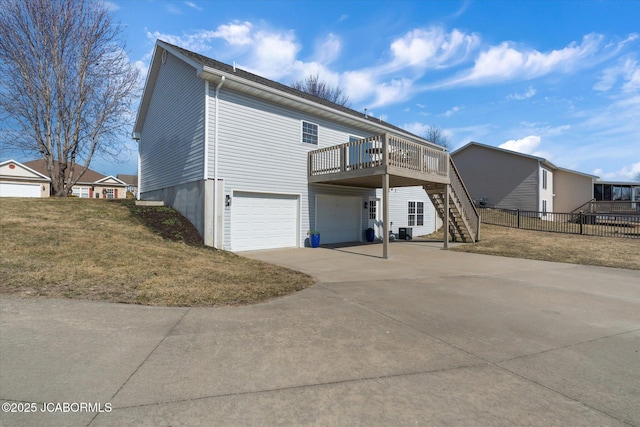 exterior space featuring fence, a garage, driveway, a wooden deck, and stairs