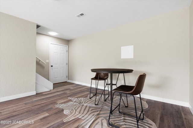 dining space featuring visible vents, baseboards, and wood finished floors