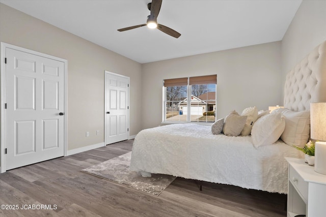 bedroom with a ceiling fan, baseboards, and wood finished floors