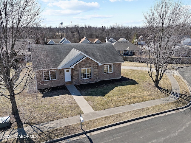 view of front of home featuring a shingled roof and a front yard