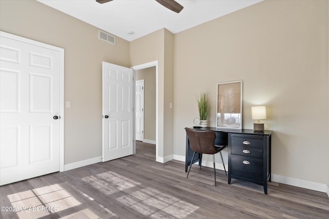 office space featuring a ceiling fan, baseboards, visible vents, and wood finished floors