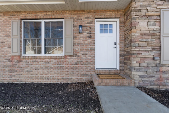 doorway to property with stone siding and brick siding