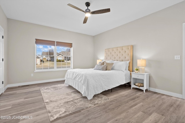 bedroom with wood finished floors, a ceiling fan, and baseboards