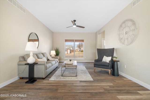 living area featuring a ceiling fan, wood finished floors, visible vents, and baseboards