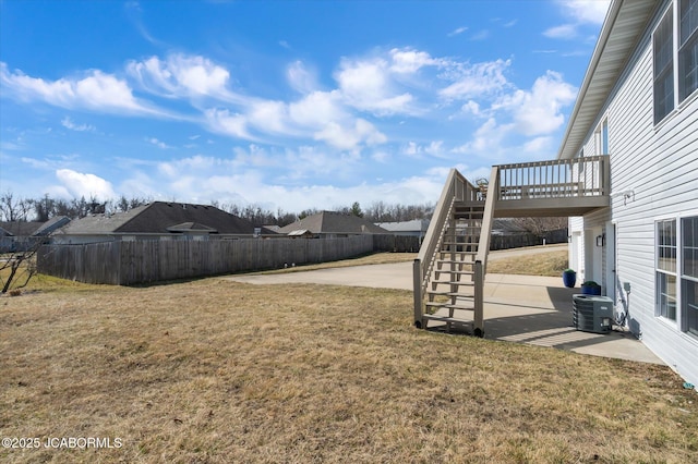 view of yard with a deck, central AC, fence, stairway, and a patio area