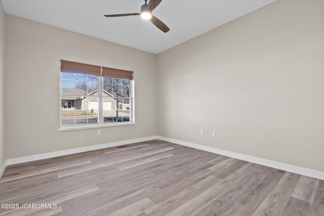 spare room with a ceiling fan, baseboards, and wood finished floors