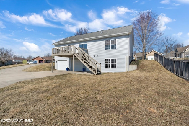 back of house with a yard, stairway, a garage, driveway, and a wooden deck