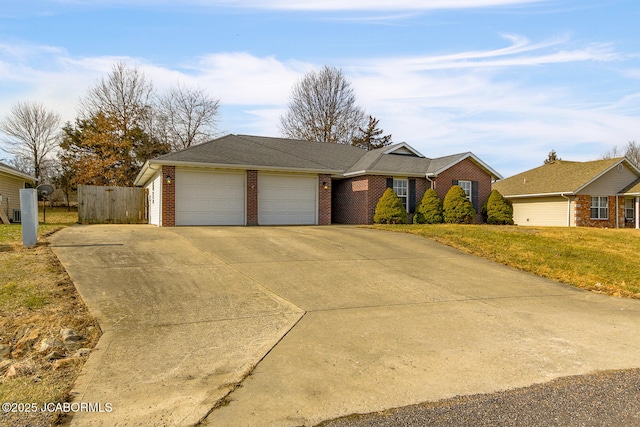 ranch-style home featuring a garage and a front lawn