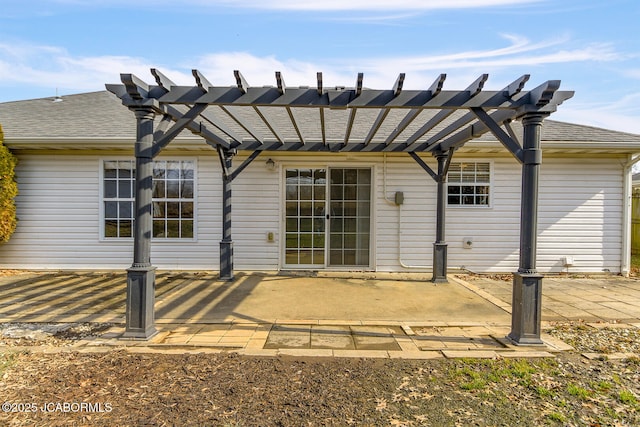 rear view of house featuring a pergola and a patio area