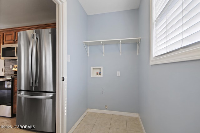 kitchen featuring tasteful backsplash, light tile patterned floors, and appliances with stainless steel finishes