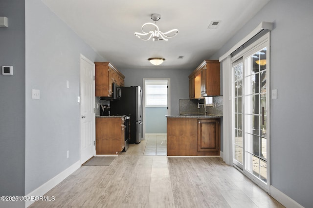 kitchen with sink, light hardwood / wood-style flooring, range, decorative backsplash, and a chandelier