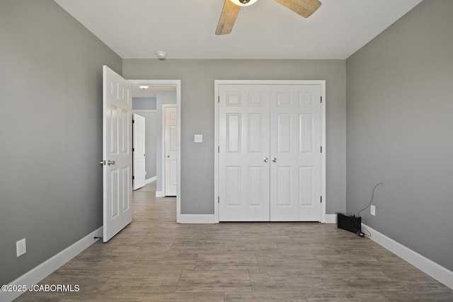 unfurnished bedroom featuring ceiling fan, a closet, and light hardwood / wood-style flooring