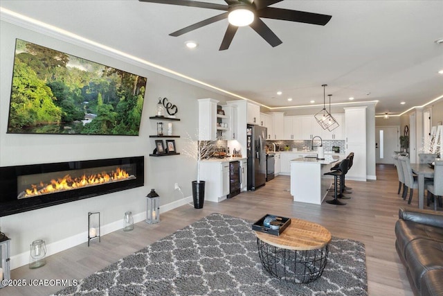 1055 Topsider Ln Unit 212, Osage Beach, MO 65065 - living room with ceiling fan, recessed lighting, wine cooler, a glass covered fireplace, and wood finished floors