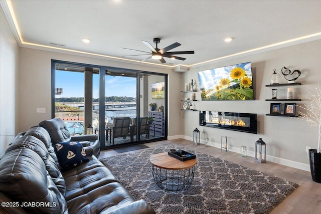 1055 Topsider Ln Unit 212, Osage Beach, MO 65065 - living area featuring ceiling fan, a glass covered fireplace, wood finished floors, ornamental molding, and recessed lighting