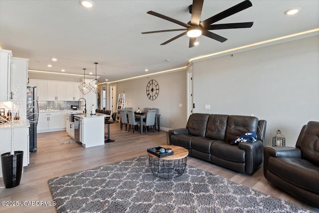 1055 Topsider Ln Unit 212, Osage Beach, MO 65065 - living room with a ceiling fan, recessed lighting, light wood-style floors, and crown molding