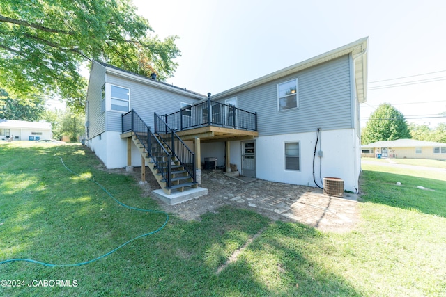 rear view of property with a wooden deck, a yard, and central AC