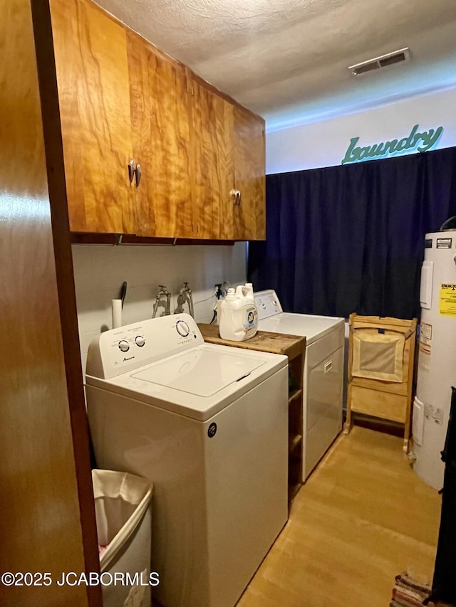 508 S Poplar St, Chamois, MO 65024 - washroom with separate washer and dryer, electric water heater, light wood-type flooring, and cabinet space