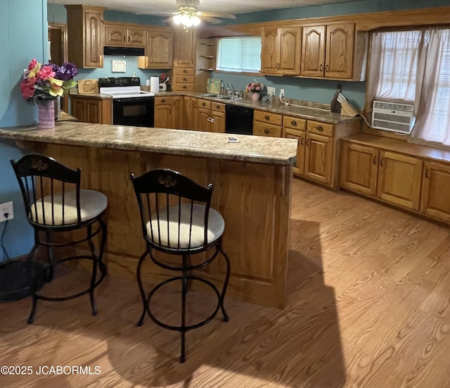 508 S Poplar St, Chamois, MO 65024 - kitchen featuring electric range oven, cooling unit, black dishwasher, a breakfast bar, and light wood-style flooring