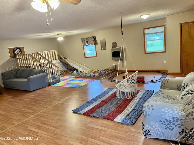 508 S Poplar St, Chamois, MO 65024 - living room featuring a textured ceiling, a ceiling fan, wood finished floors, and stairway