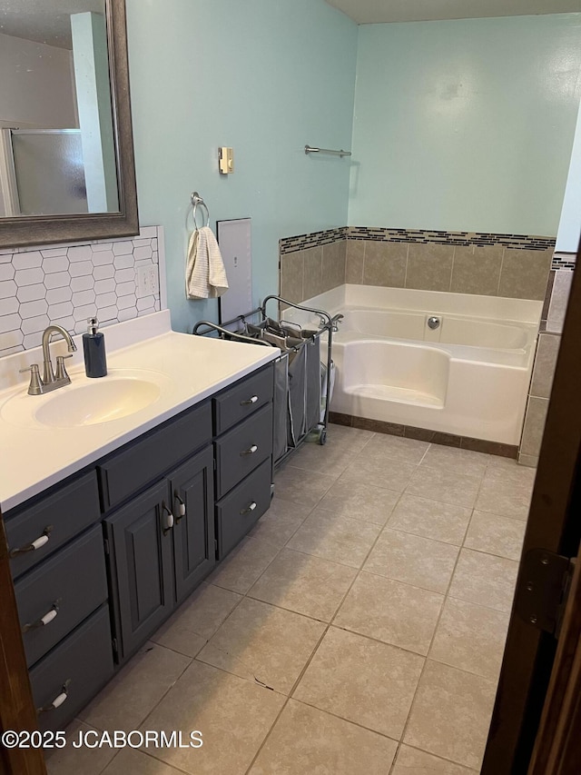 508 S Poplar St, Chamois, MO 65024 - full bath featuring tile patterned flooring, vanity, a bath, and decorative backsplash
