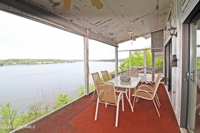 sunroom / solarium featuring a ceiling fan and a water view