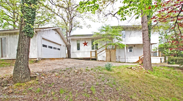 tri-level home with a detached garage and an outbuilding