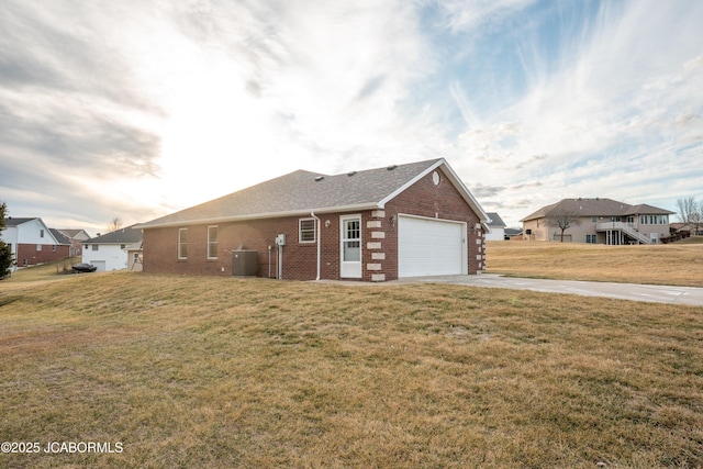 view of front of house with driveway, roof with shingles, an attached garage, a front yard, and brick siding